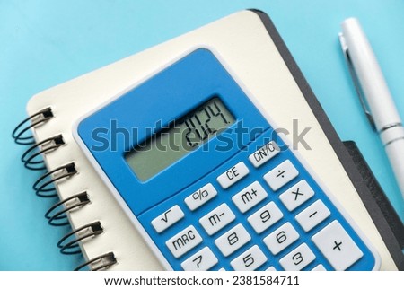 Concept of new year finance, inflation, recession, tax, budget and cost of living. Financial reminder of fiscal year 2024. 2024 on calculator screen.	