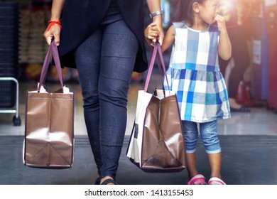 Concept Of No Plastic Bag. Kids And Young Asian Mom In Casual Suit Holding A Consumables From Mall With The Bag Can Be Used Again To Brings Back Home.