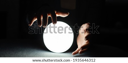Concept of occult sciences. Women's hands on a ball to guess the future
