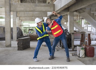 concept occupational risk management in industry,workplace safety.senior help young man worker that small log is being fallen near hit his head,engineer team working in the building under construction - Shutterstock ID 2319590975