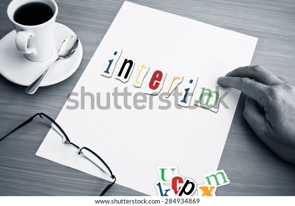 concept office cup of coffee and word interim on white\
page 