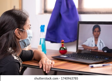 Concept Of Online Chat, Telehealth, Or Tele Counseling With Nurse Or Doctor On Screen During Coronavirus Or Covid-19 Pandemic - Girl In Medical Mask Listining To Doctor On Laptop At Home.