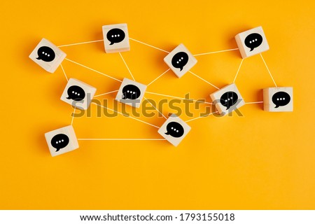 Concept of online communication or social networking. Wooden cubes with speech bubbles linked to each other with lines. 