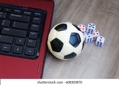 Concept of online gambling and games. Laptop, dice and  soccer / football ball - Powered by Shutterstock