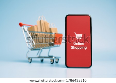 Concept online Sopping. boxes and shopping bag on Trolley with Smartphone Online Shopping screen.