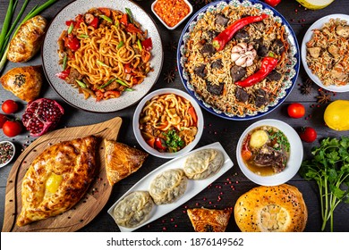 The concept of oriental cuisine. Assorted Uzbek food set, pilaf, samsa, lagman, manta, shurpa central asia food. Homemade Uzbek pilaf or plov from lamb served in cast iron cookware - Shutterstock ID 1876149562