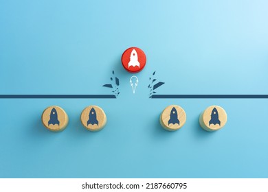 Concept Of Overcoming Barriers, Goal, Target. Red Wooden Cube With Rocket Launch Icon Breaking Through Obstacle On Blue Background