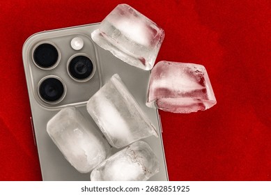 The concept of overheating and fire hazard. Cooling the latest smartphone with ice cubes. Excessive processor operating temperature damages the Phone.