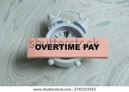 Concept of overtime pay write on sticky notes isolated on Wooden Table. For labor law and payroll