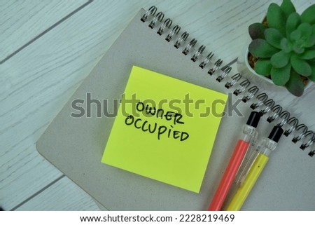 Concept of Owner Occupied write on sticky notes isolated on Wooden Table.