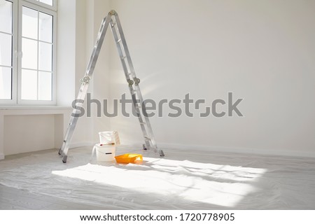 Concept painting work repair painting. Ladder paint cans in a white room for repair