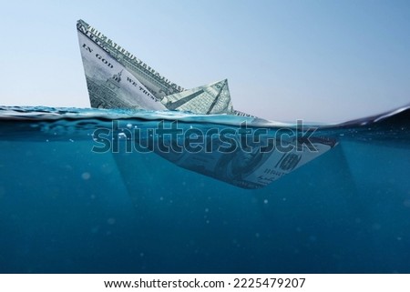 Concept paper dollar boat sinking in the sea with a view underwater. Finance and crisis, a creative idea. Falling exchange rates. Insurance 