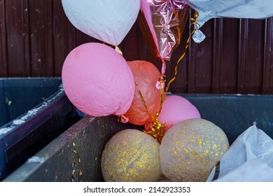 Concept. The party is over. Deflated balloons in a garbage can