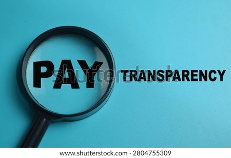 Concept of pay transparency write on book isolated on Wooden Table. For salary disclosure requirements and wage equity