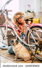 Concept Of People Friends With Animal Dog - Woman Work On A Coloured Funny Bike At Home With Her Best Friend Old Pug Is Sit Down Near Her - Friendship And Happiness With Pet Therapy And Handcraft Work
