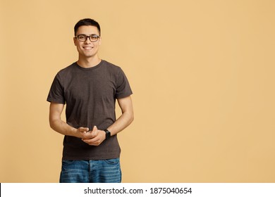 Concept Of People, Youth, Emotions. Smiling Attractive Young Student Blogger Guy In Glasses With Smart Watch In Casual Looks At Camera, Isolated On Light Background, Empty Space, Studio Shot