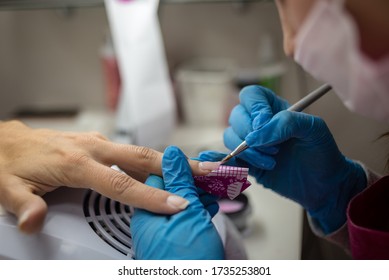 Concept: Personal Beauty Care. Close Up Detail Of Professional Hands Rebuilding Nails With Special Gel And Tool. Professional Manicure Salon.