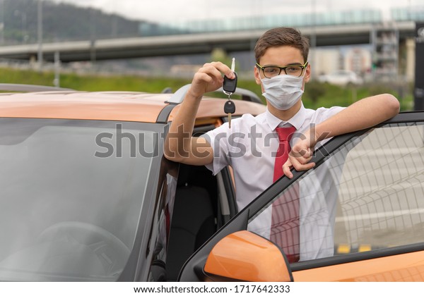 Concept of a personal driver\
service. Chauffeur-drive. Personal chauffeur in a protective face\
mask