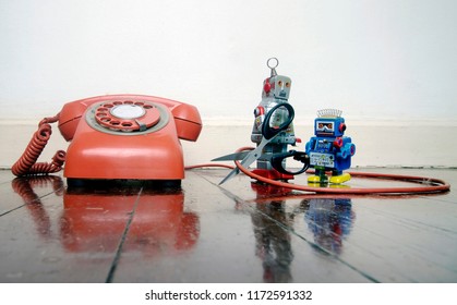 Concept Phone Line Being Cut Of With Retro Robots On A Wooden Floor 