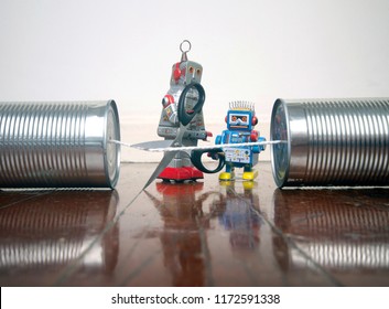 Concept Phone Line Being Cut Of With Retro Robots On A Wooden Floor 