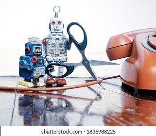 Concept Phone Line Being Cut Of With Retro Robots On A Wooden Floor