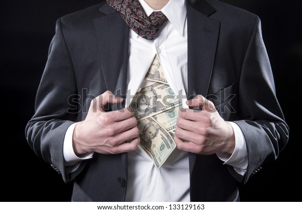Concept photo for hidden\
money showing a businessman pulling back his shirt exposing twenty\
dollar bills