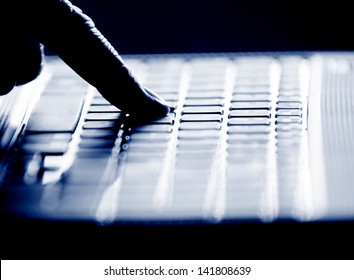 Concept photo in high contrast black and white of hacker's single finger on keyboard