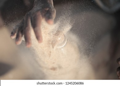 Concept Photography, Eco Building: Aerial Close Up Of And African Man Hand Filling Up With Sand A Plastic Water Bottle, Outdoors On A Sunny Summer Day, In The Gambia, Africa On Atlantic Beach