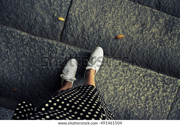 歩く脚のコンセプト画像 ビンテージ調のカラー画像 石の階段の背景に白いスニーカー靴と長いスカートの足の自撮り 上面図 の写真素材 今すぐ編集