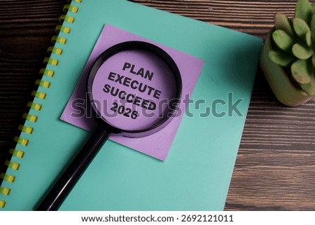 Concept of plan execute succeed 2026 write on sticky notes isolated on Wooden Table.