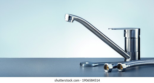 Concept plumbing work with water tap and tools on dark surface with copy space. Banner.