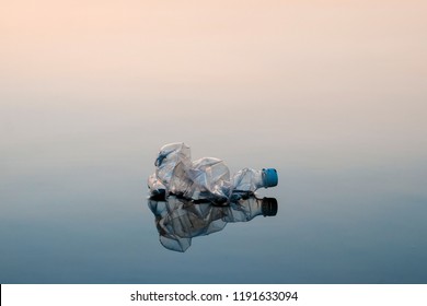 Concept of pollution, creative background. A plastic bottle floating in the ocean, non-decomposable plastic, pollution of the environment.