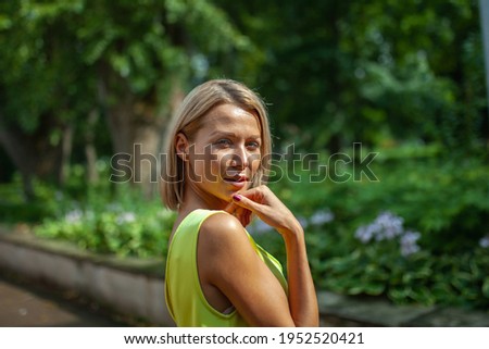 Concept portrait expressions. Young woman  outdoor portrait in city park. Looks over his shoulder straight into the camera. 