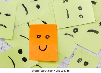 Concept For A Positive Attitude With Small Office Notes With Multiple Faces And One That Stands Out With A Smile