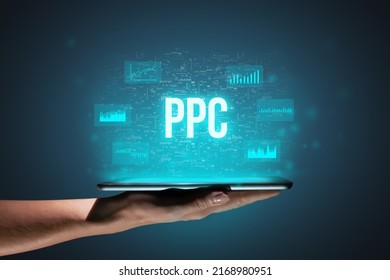 Concept PPC or Pay per click. Business acronym. Holographic icons and text over tablet in hands.