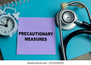 Concept of precautionary measures write on sticky notes isolated on Wooden Table.