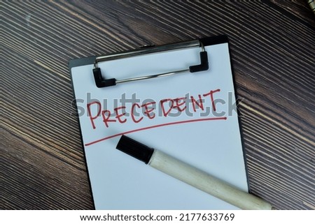 Concept of Precedent write on a paperwork isolated on Wooden Table.