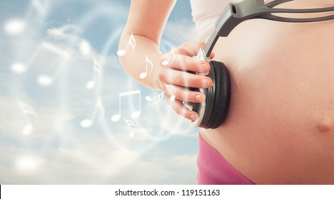 concept pregnancy and music. belly of pregnant woman and headphones on the sky background - Powered by Shutterstock