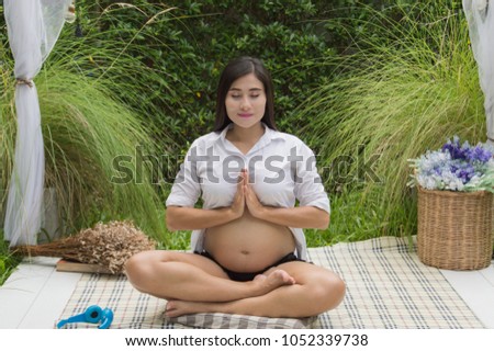 Concept of pregnancy.  Pregnant women are exercising. Pregnant women are taking care of their health with yoga. Pregnant woman playing yoga in the garden Stock photo © 