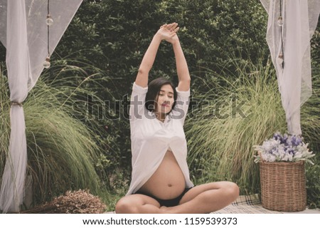 Concept of pregnancy. Pregnant women are exercising. Pregnant women are taking care of their health with yoga. Pregnant woman playing yoga in the garden. Stock photo © 