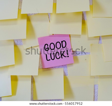 Concept of priority on written good luck on red sticky notes within many sticky notes.