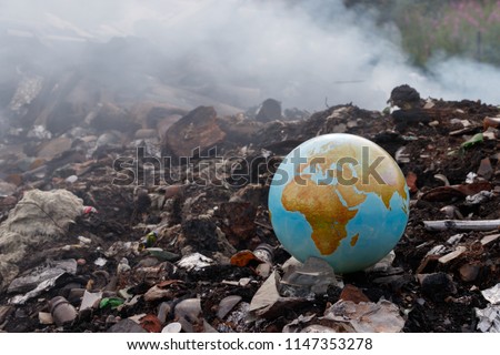Concept to the problem of the environment - burning of garbage. Incineration plants are harmful to the environment. Planet earth is thrown into the trash. Garbage burns, smoke comes. Toxic dioxins.