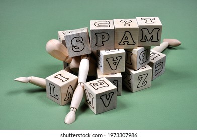 The concept of the problem of receiving spam. A wooden man littered with cubes and the inscription SPAM. - Powered by Shutterstock