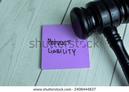 Concept of Product Liability write on sticky notes with gavel isolated on Wooden Table.