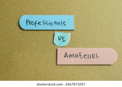 Concept of Professionals vs Amateurs write on sticky notes isolated on Wooden Table.