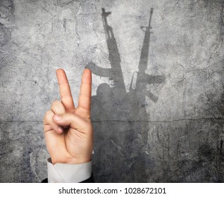 Concept Of Propaganda. The Hand Folded Into The Symbol Of The World Casts A Shadow In The Form Of A Weapon. Secret Power.