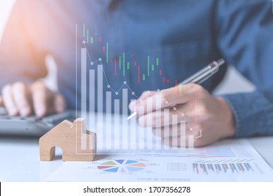 Concept Of Property Investment And House Mortgage Financial. A Business Man, Agent Calculating Income, Sales, 
Or House Dept While Economy Crisis Effect From Coronavirus Pandemic. Stock Market Graph.