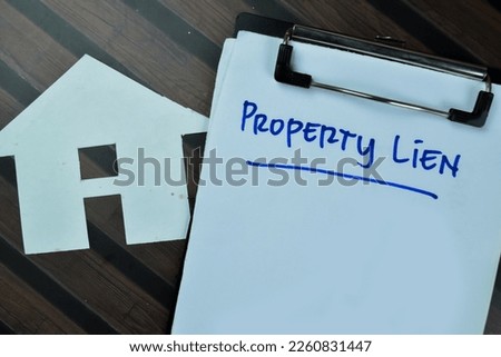 Concept of Property Lien write on paperwork isolated on Wooden Table.