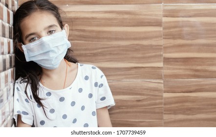 Concept Of PTSD Or Post-traumatic Stress Disorder After Covid-19 Or Coronavirus Pandemic - Young Teenager Girl With Medical Mask Wearing Sat By Leaning On Well In Sad, Fear, Or Anxiety