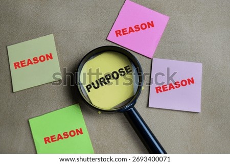 Concept of purpose and reason write on sticky notes isolated on Wooden Table.